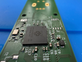Close-up of a green circuit board with electronic components on a blue background